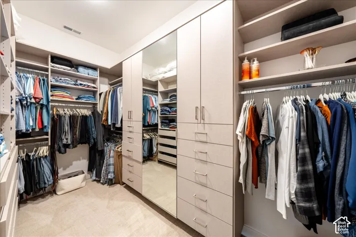 Custom closet system featuring built-in cabinetry, multiple drawers, open shelving, and full-length mirror