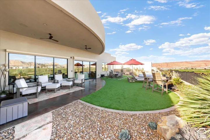 Expansive outdoor living area featuring a curved patio, artificial turf, and a gravel hardscape