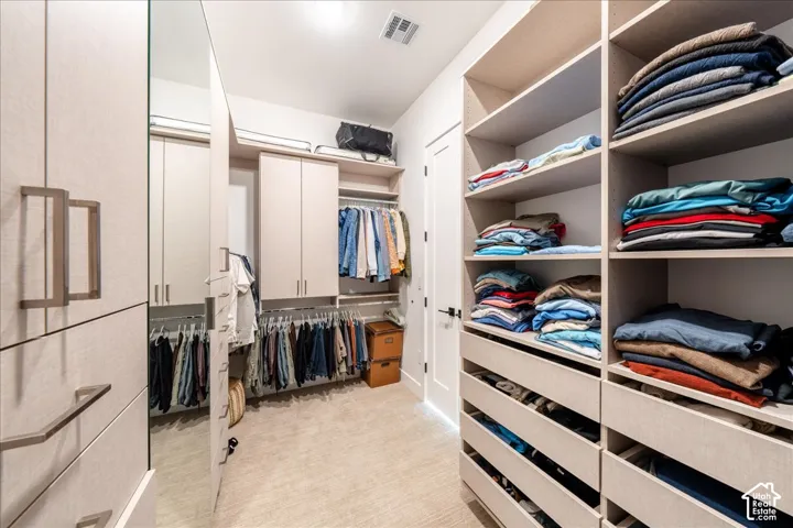 Custom closet system featuring extensive shelving, built-in drawers, hanging rods, and integrated cabinetry