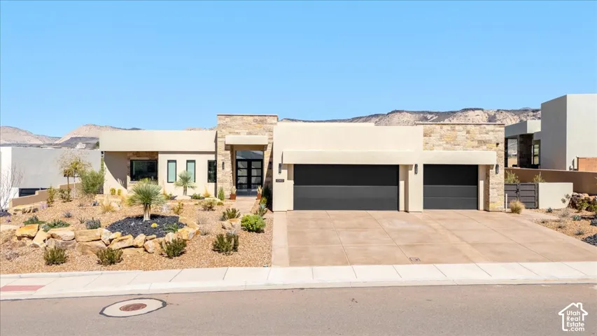 Contemporary exterior with a stone accent wall, xeriscaped front yard, and a two-car garage
