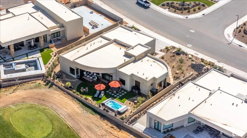 Contemporary residential architecture featuring a private spa, paved patio, and landscaped turf