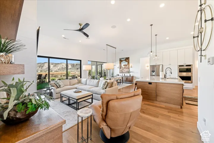 Open-concept living area with vaulted ceilings, a kitchen island, floor-to-ceiling windows, and recessed lighting