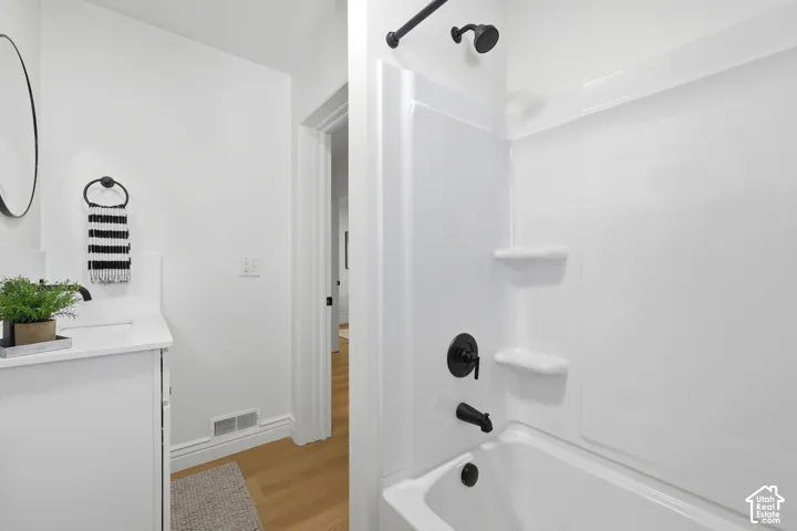 White vanity with a single basin sink and wall-mounted faucet