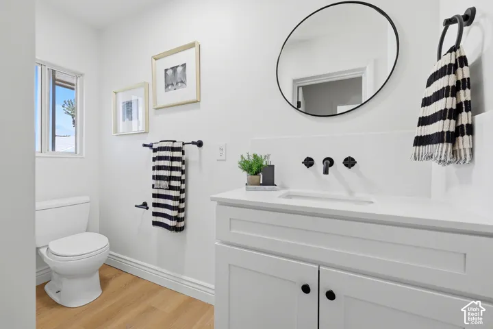 White vanity with shaker-style cabinetry, matte black hardware, and integrated rectangular sink