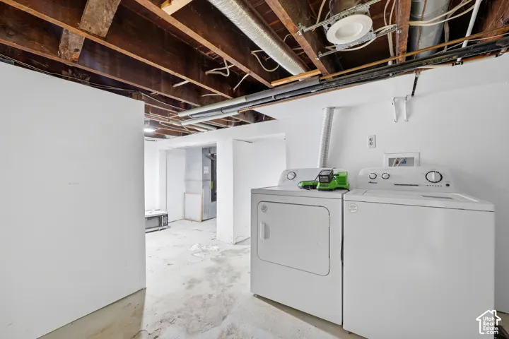 Basement laundry room with washer and dryer included.