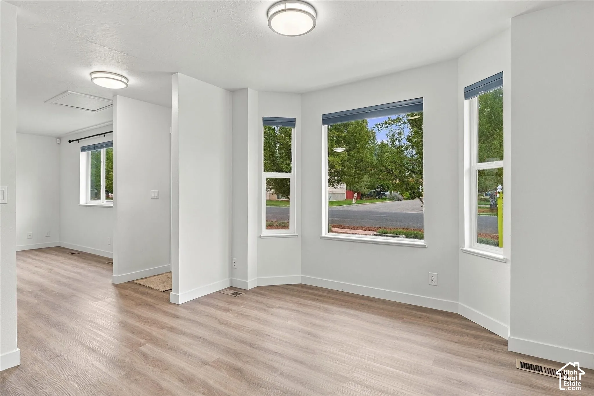 Wood-finish flooring, recessed lighting, multiple windows, and a neutral color palette