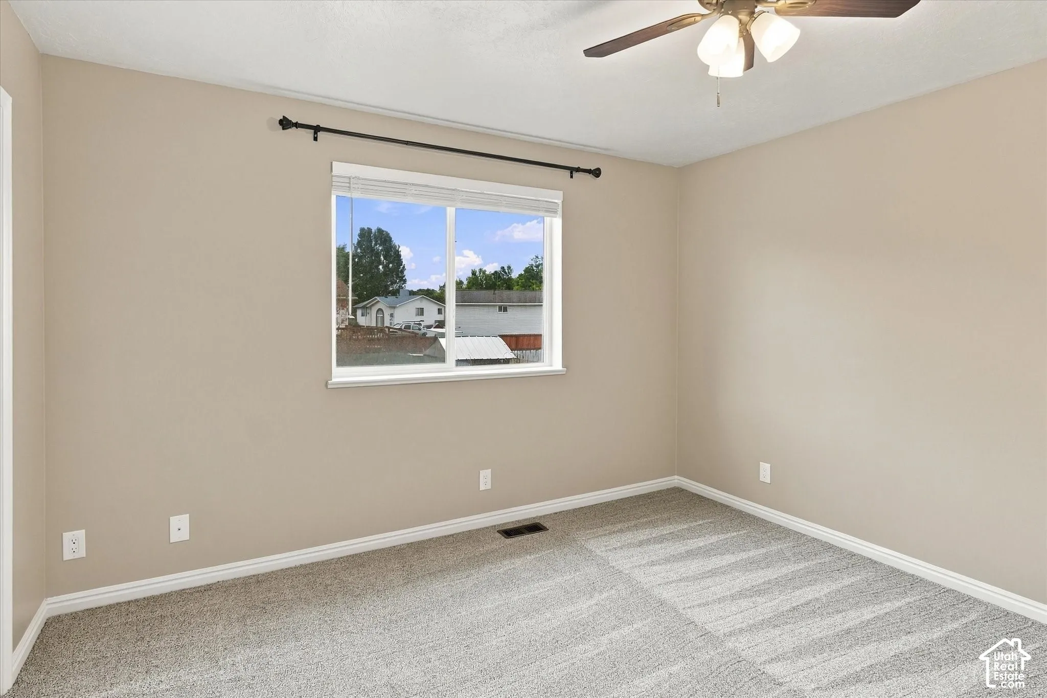 Neutral-toned walls complement patterned carpeting