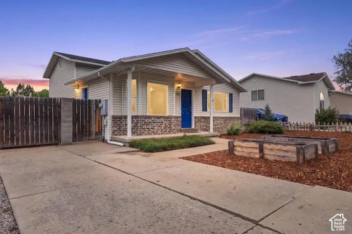 Siding exterior with brick veneer and coordinating shutters, covered entry, and concrete driveway
