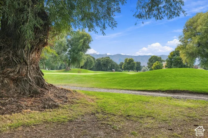 Expansive green golf course with manicured fairways and distant mountains