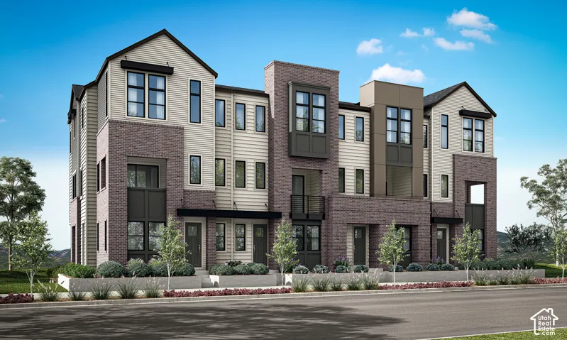 Modern multi-story facade featuring brick and siding accents, multiple windows, and a dark-toned roof