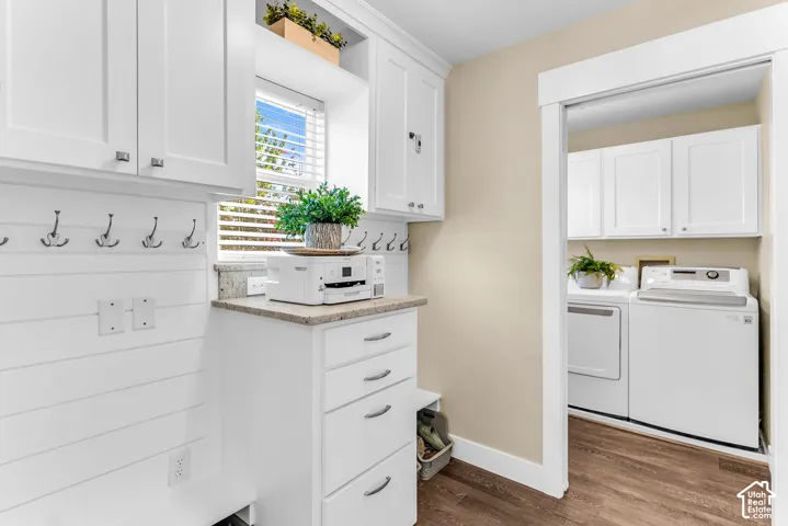 White shaker-style cabinetry with chrome hardware, granite-look countertop, wood-finish flooring, and shiplap wall accents