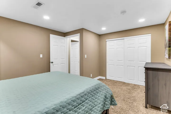 Recessed lighting, warm neutral wall tones, carpeted flooring, and white panel doors