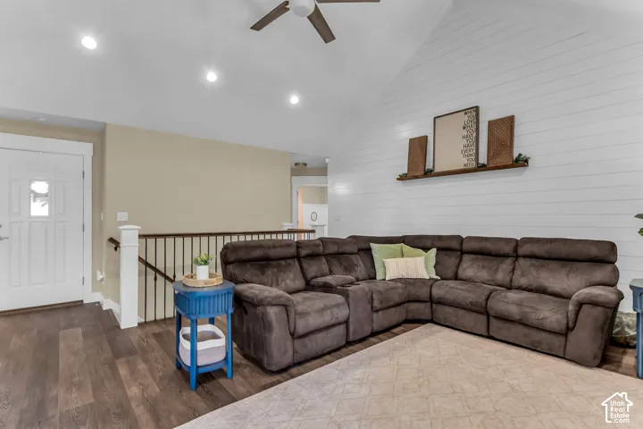 Vaulted ceiling with a ceiling fan, recessed lighting, wood-finish flooring, and white shiplap accent wall