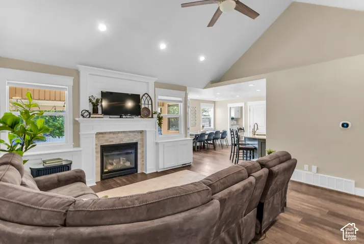 Vaulted ceiling with a ceiling fan, recessed lighting, and wood-finish flooring