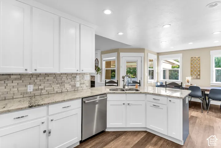 White shaker cabinetry with chrome hardware, stone countertops with a mosaic tile backsplash, a stainless steel dishwasher, and recessed lighting