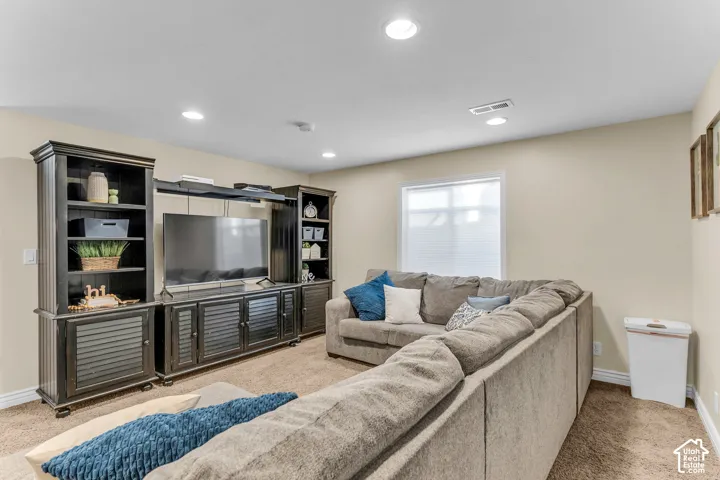 Recessed lighting, light-toned walls, and a single window with blinds