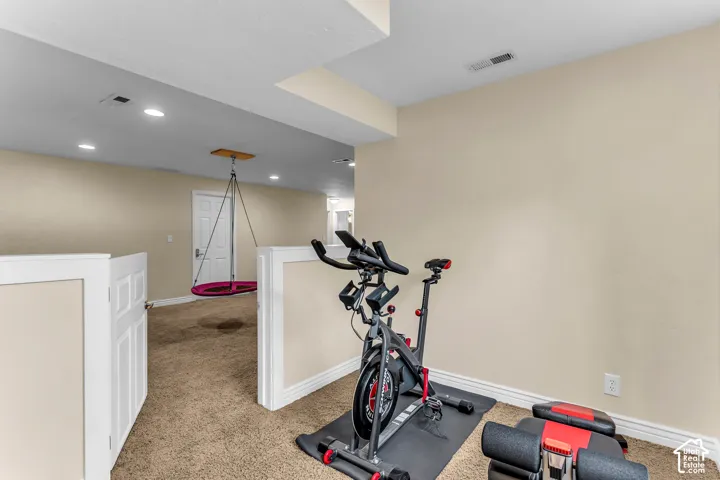 Carpeted room with recessed lighting and a neutral wall color