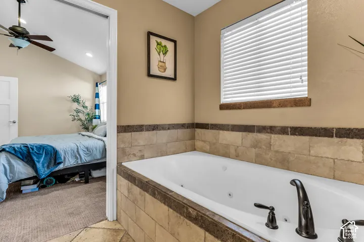 Built-in jetted tub with oil-rubbed bronze fixtures, surrounded by stone tile