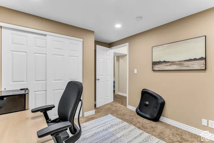 Recessed lighting, warm neutral wall paint, carpeted flooring, and white trim throughout