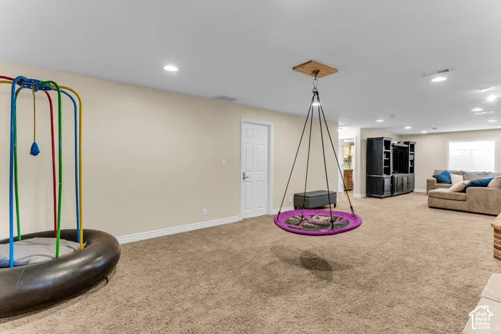 Spacious room featuring neutral carpeting and recessed lighting