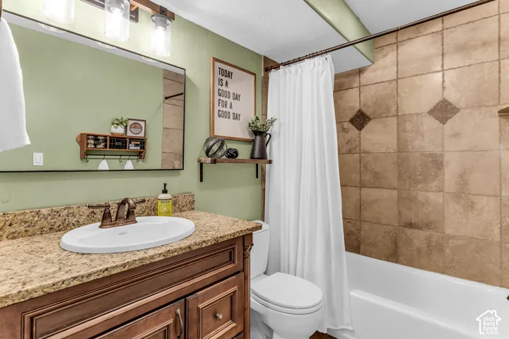 Bathroom featuring a built-in vanity with a granite countertop, undermount sink, and bronze-finish faucet