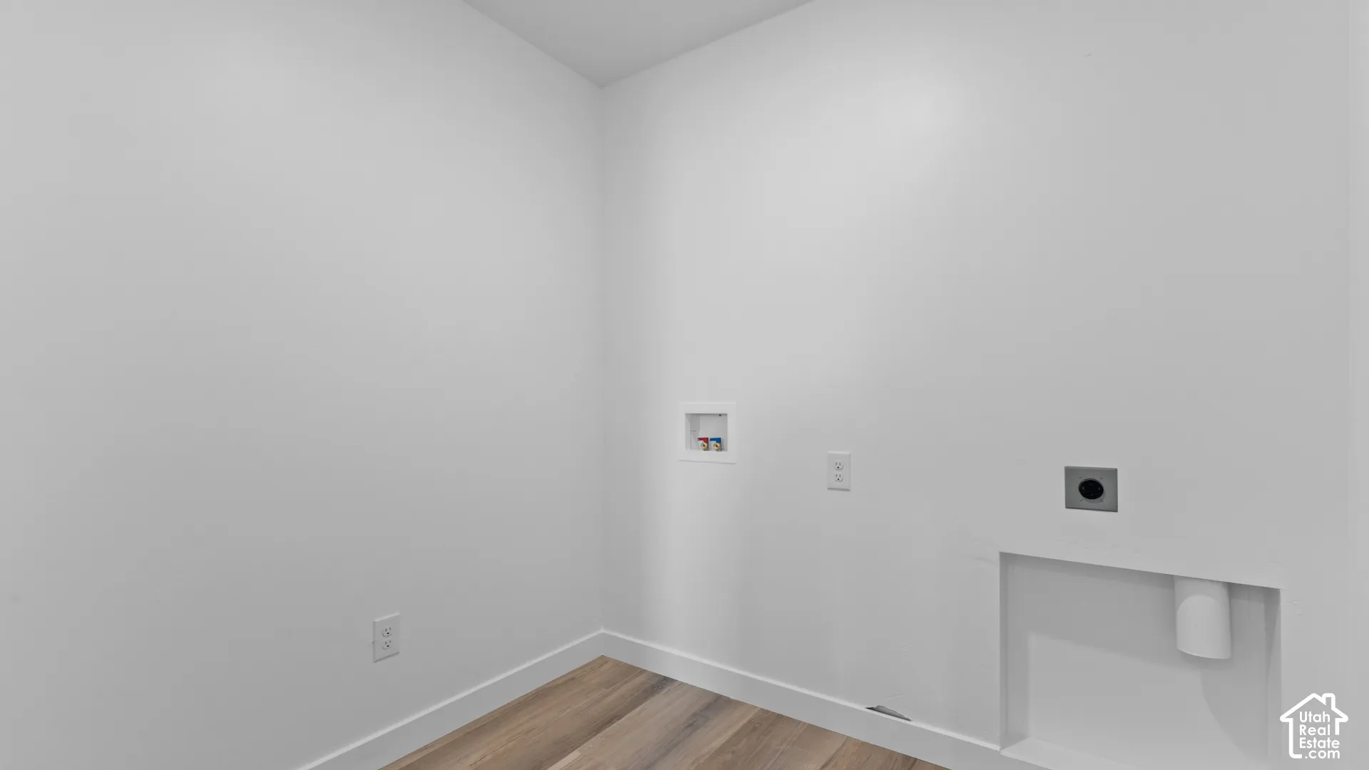 Wood-finish flooring with white wall finishes and integrated laundry hookups