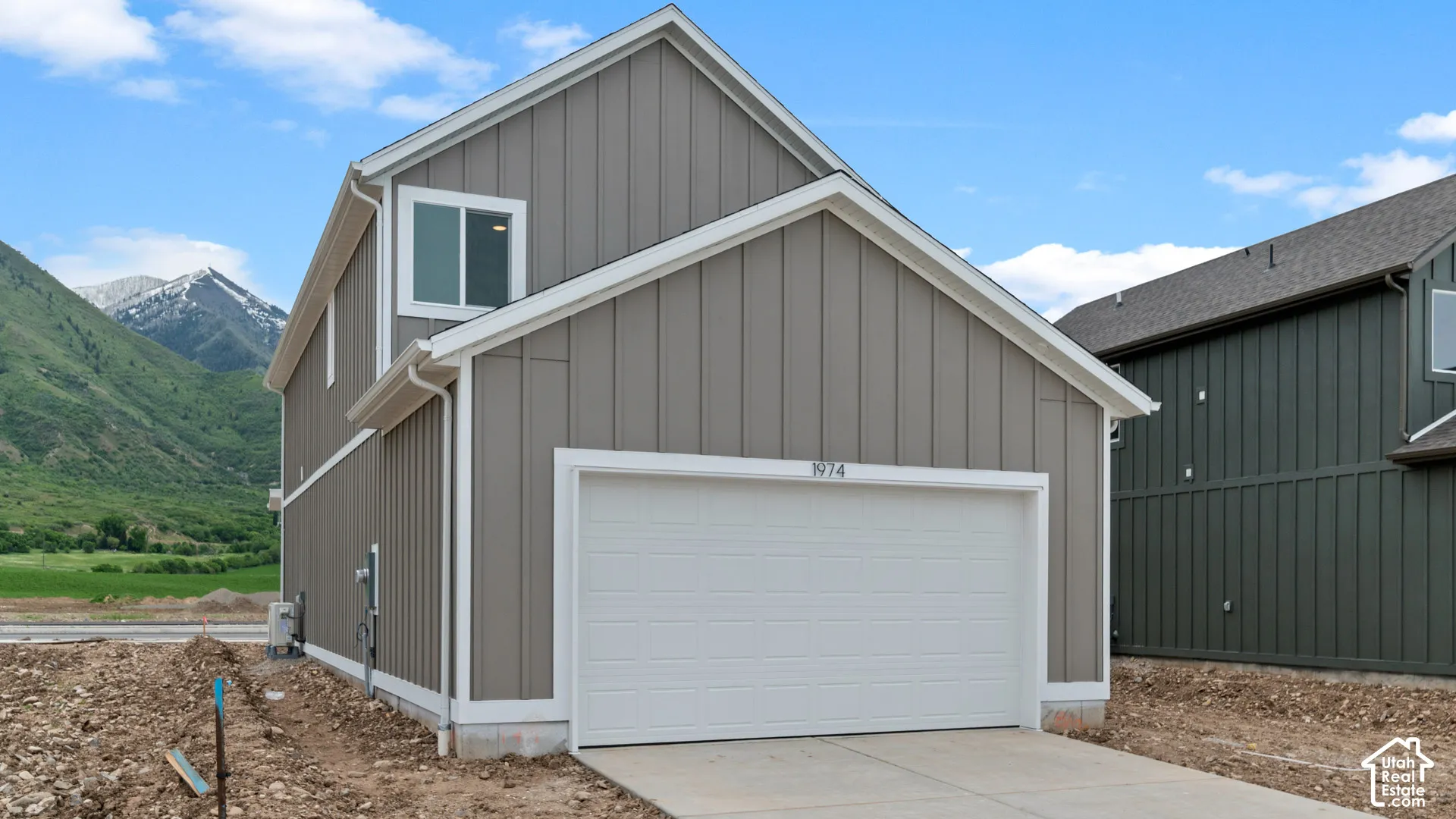 Contemporary exterior with board and batten siding, attached garage, and white trim accents