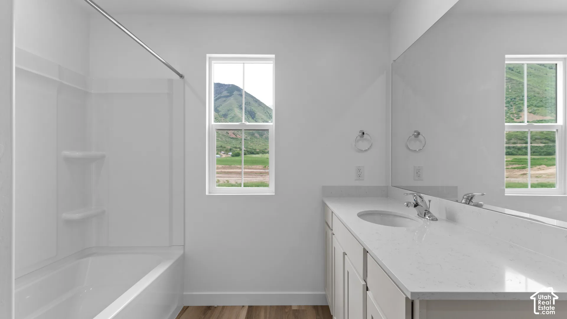 Full-width vanity with dual sinks, light-toned countertop, and undermount sinks