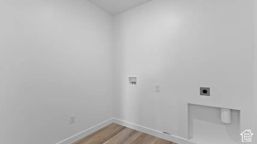 Wood-finish flooring with white wall finishes and integrated laundry hookups