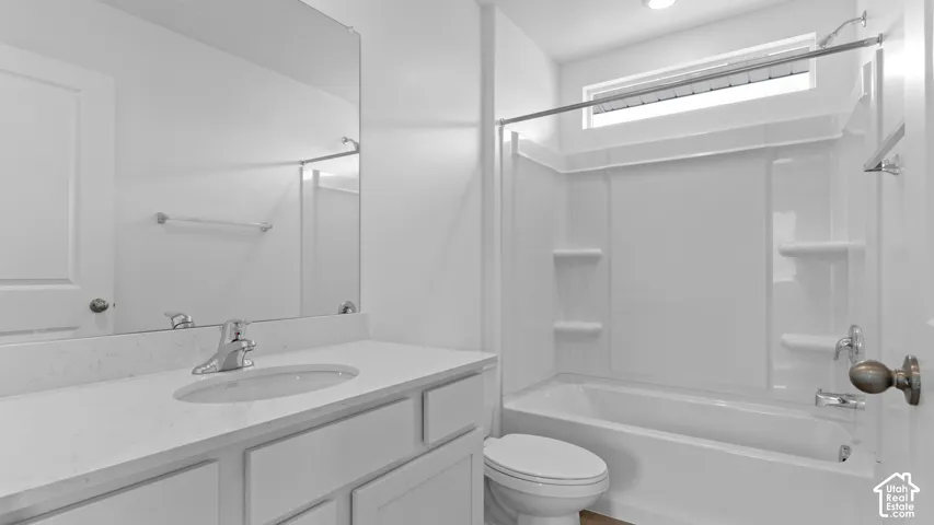 Bathroom featuring a vanity with an integrated sink, polished chrome faucet, and expansive mirror