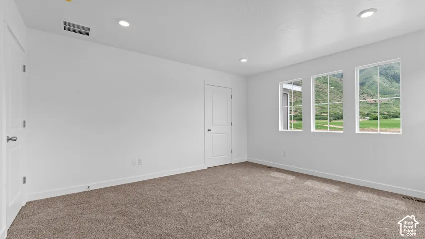 Recessed lighting, white interior doors, neutral-toned carpet, white trim, and multiple windows