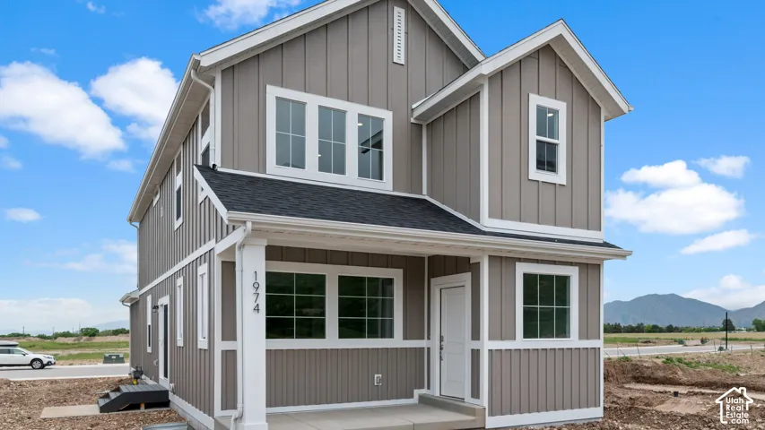 Contemporary exterior with board and batten siding, white trim accents, prominent front porch columns, and multiple windows