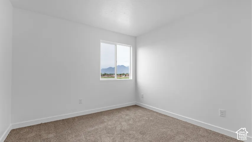 Carpeted flooring with white wall finishes, featuring a window with mountain scenery