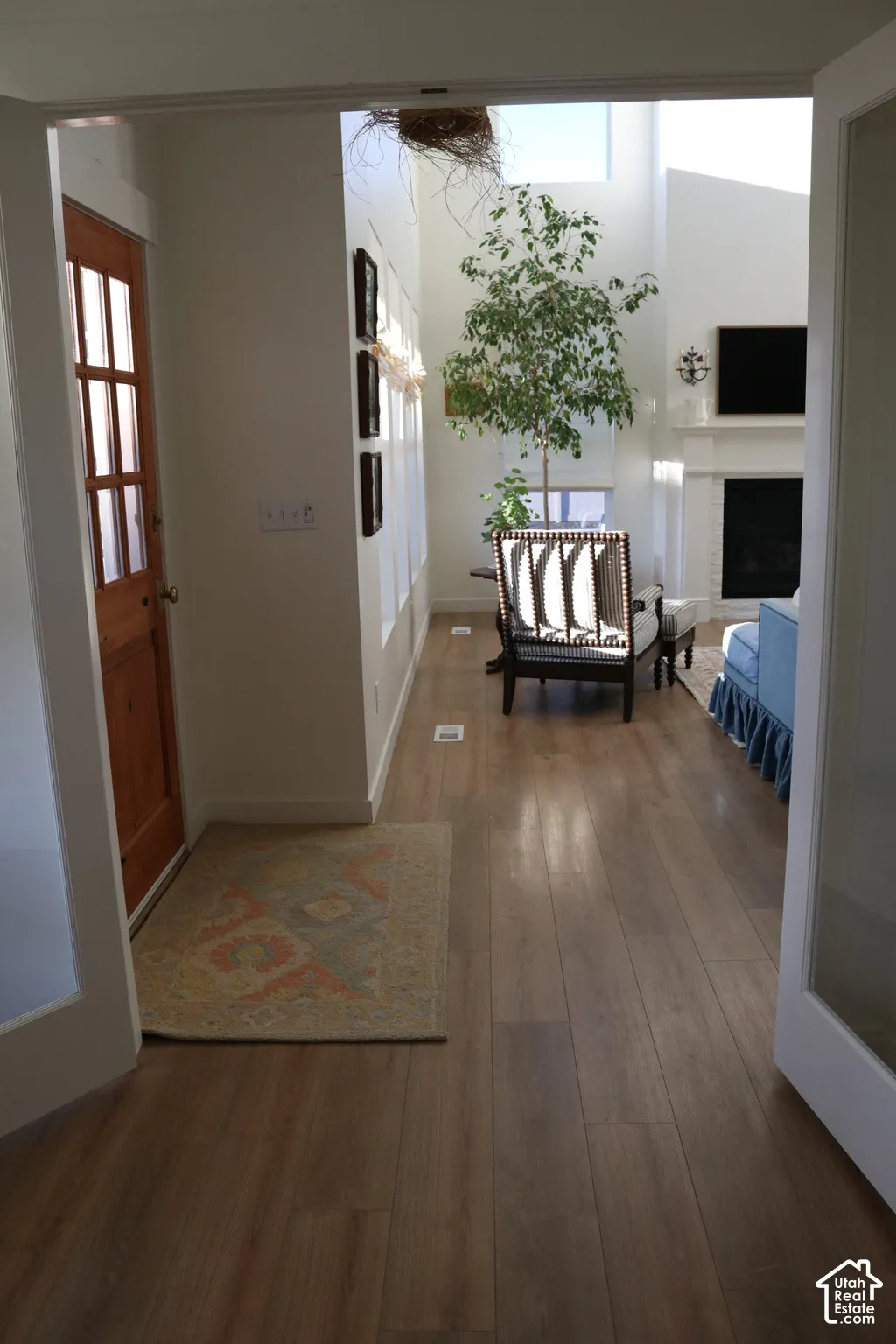 Wood-finish flooring throughout, transom windows, and a built-in fireplace with a mantel