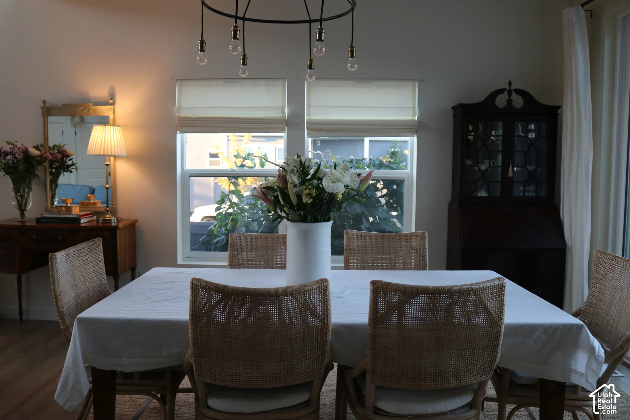 Wood-finish flooring, dual windows with Roman shades, and a built-in cabinetry unit