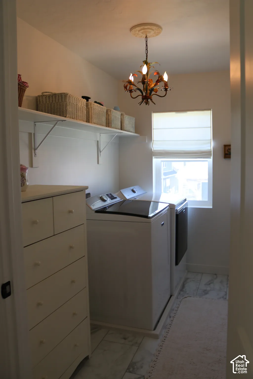 Recessed window with a roller shade, tile flooring, and wall-mounted shelving
