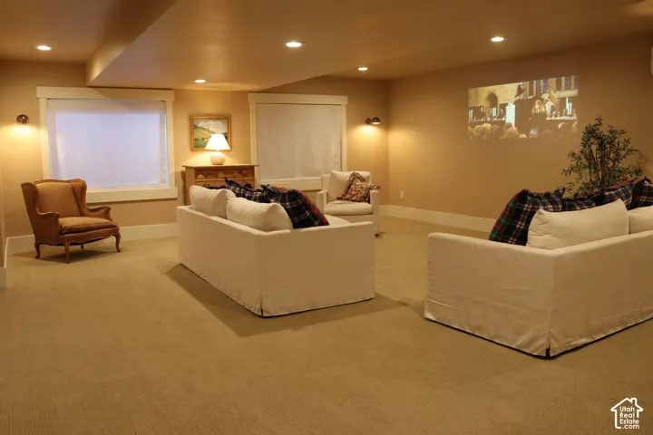 Recessed lighting illuminates a spacious room featuring a built-in projector display