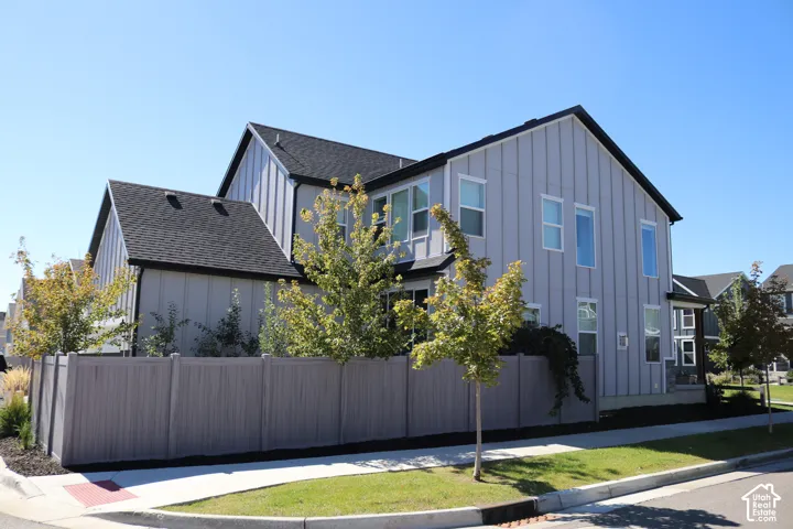 Contemporary exterior with vertical panel siding and a dark shingle roof