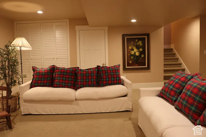 Recessed lighting, louvered bi-fold closet doors, white trim, light-colored carpeting, and a carpeted staircase