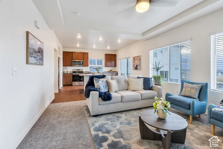 Open-concept living space with tray ceiling and recessed lighting