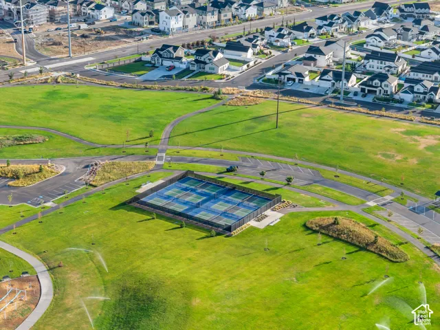 Expansive green spaces with paved pathways and tennis courts