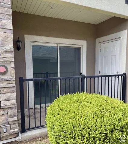 Private patio with black metal railing, offering direct outdoor access through a glass sliding door