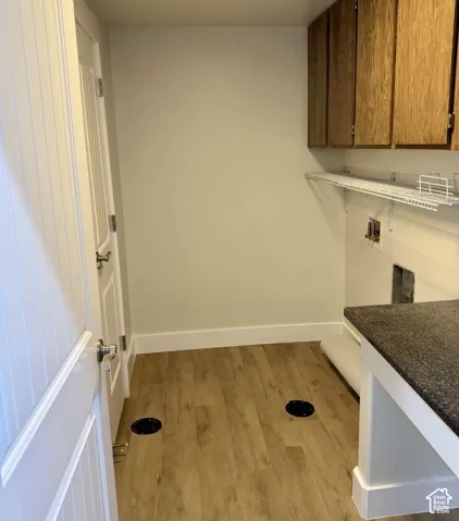 Wood-finish flooring with white trim, built-in upper cabinetry, white wire shelving, and a dark countertop
