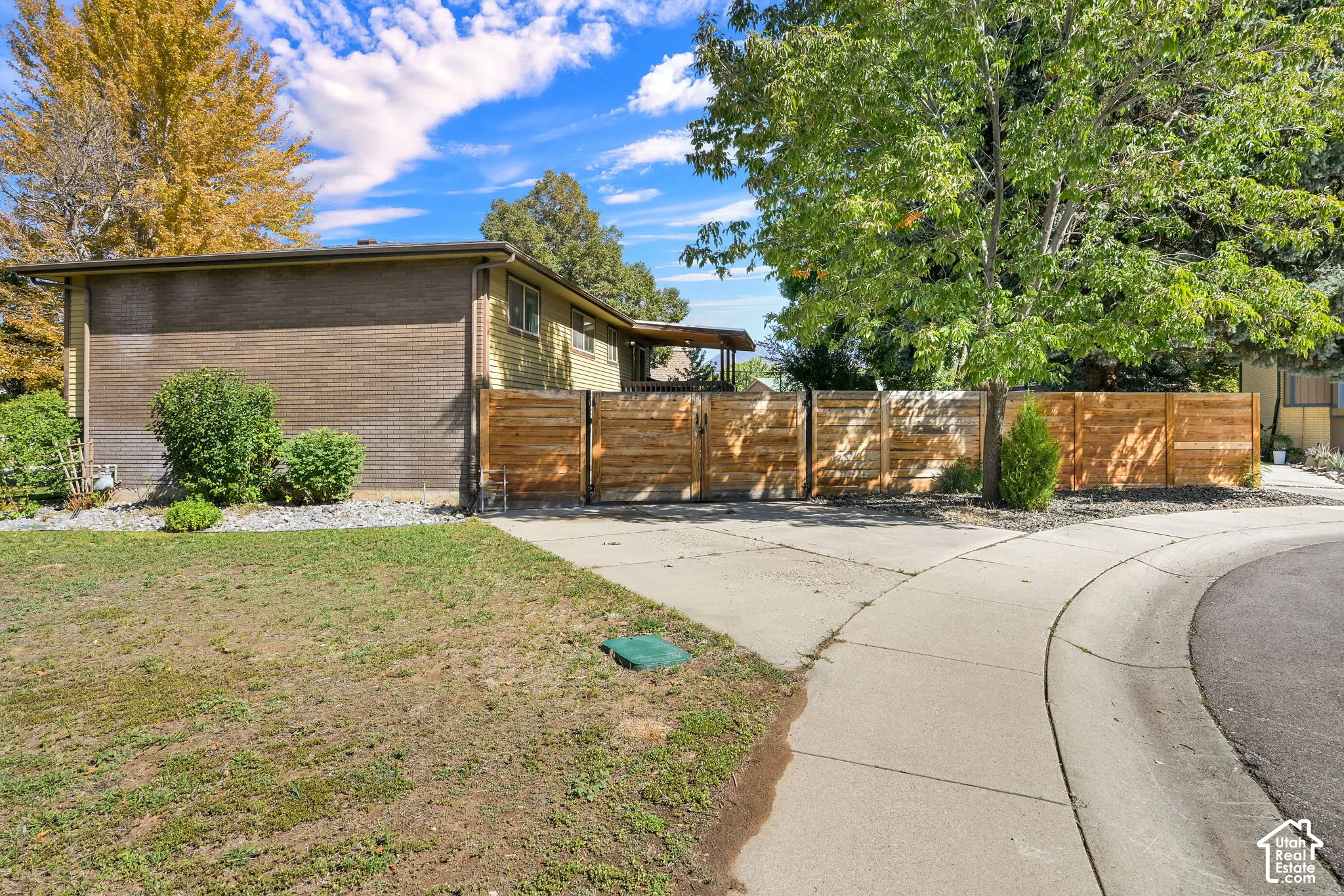 Mature trees and landscaping frame the property, fenced in yard, additional parking and access to backyard.