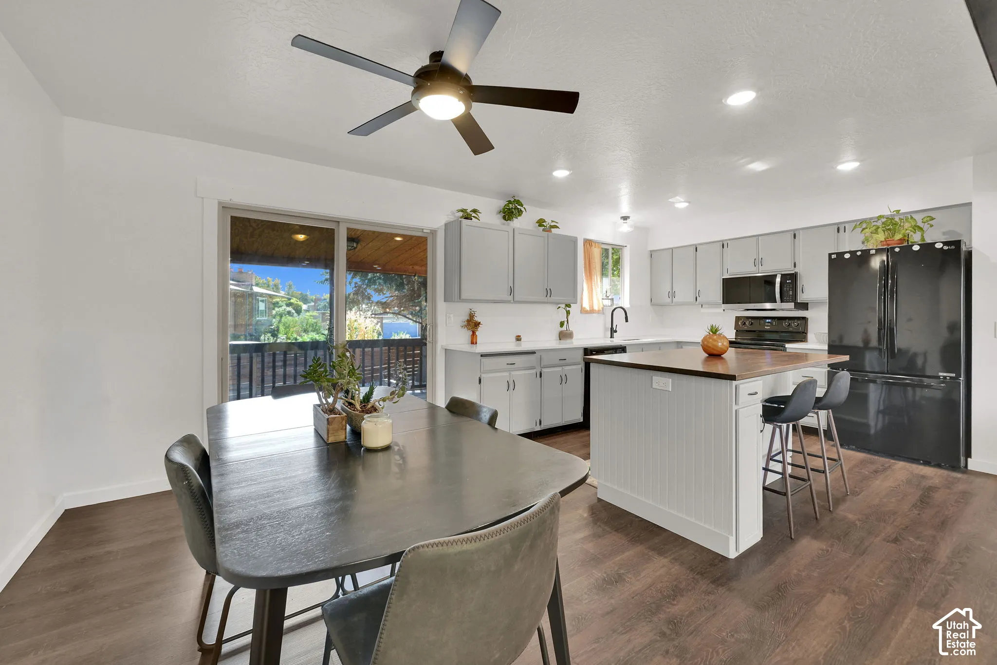 Open-concept kitchen and dining area featuring wood-finish flooring, recessed lighting, and a ceiling fan