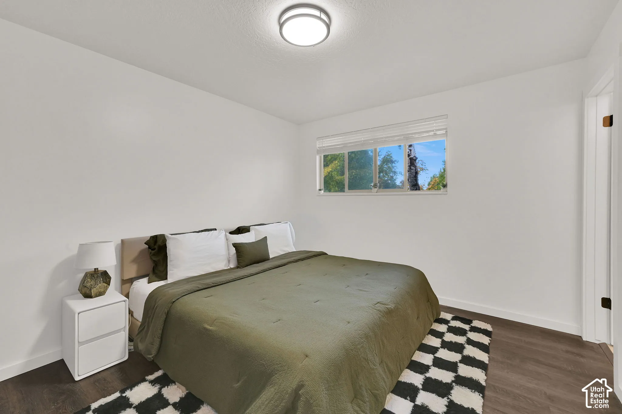 Main 3rd Bedroom with private bath. White walls, wood-finish flooring, and a flush mount ceiling light