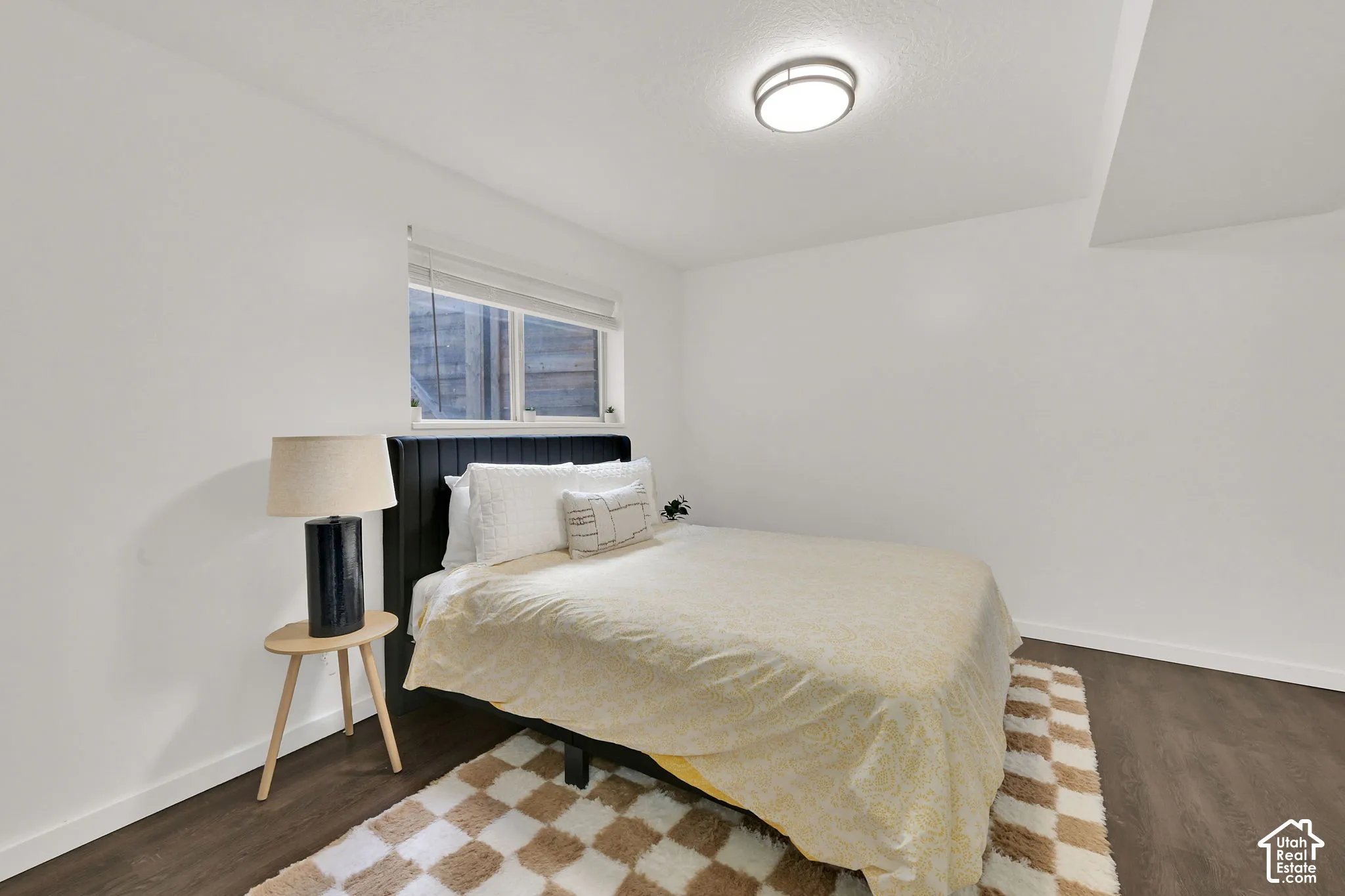 4th bedroom with window with blinds, flush-mount ceiling light fixture, wood-finish flooring, white walls, and a built-in headboard
