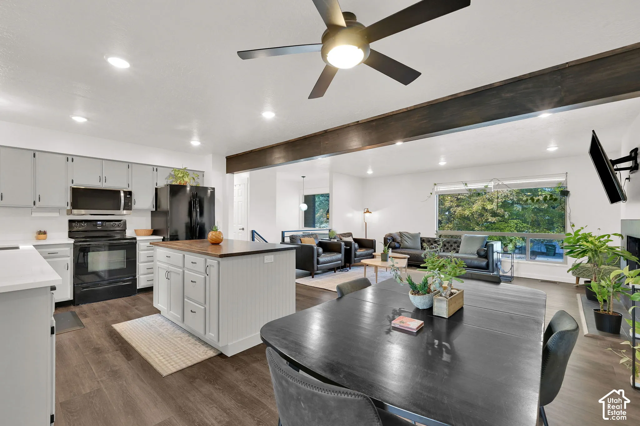 Wood-finish flooring, recessed lighting, and a dark wood ceiling beam