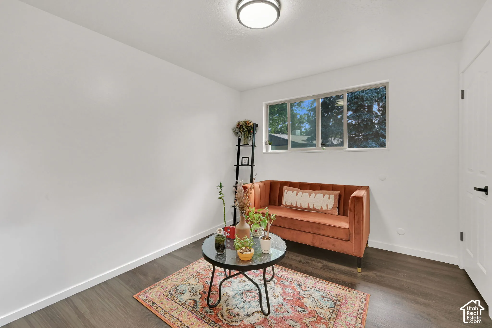1st main floor Bedroom. White walls with dark wood-finish flooring