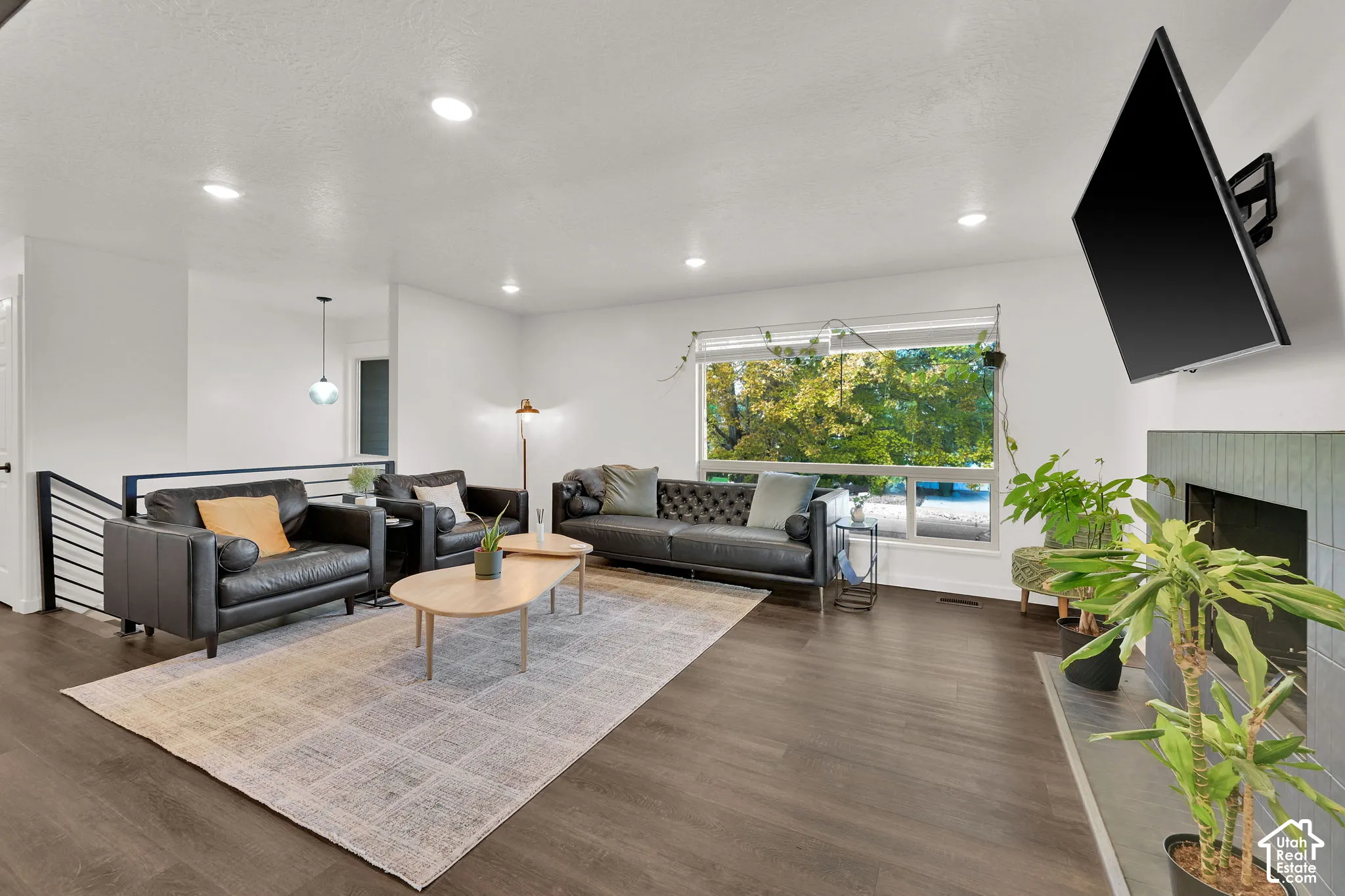 Spacious living area featuring wood-finish flooring, recessed lighting, and a large window